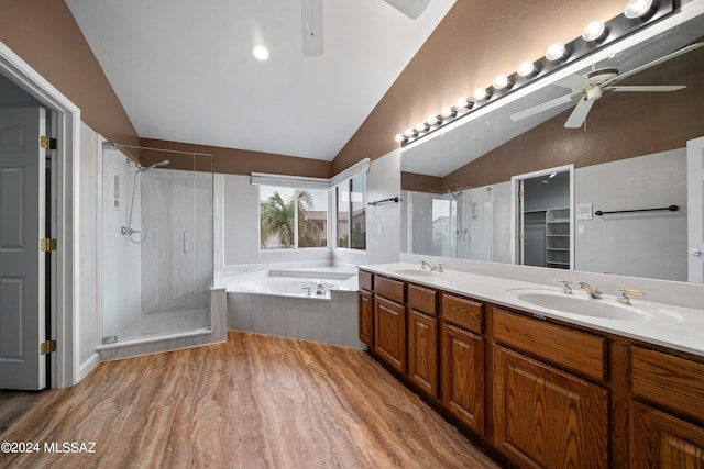 bathroom with lofted ceiling, ceiling fan, dual vanity, hardwood / wood-style floors, and plus walk in shower