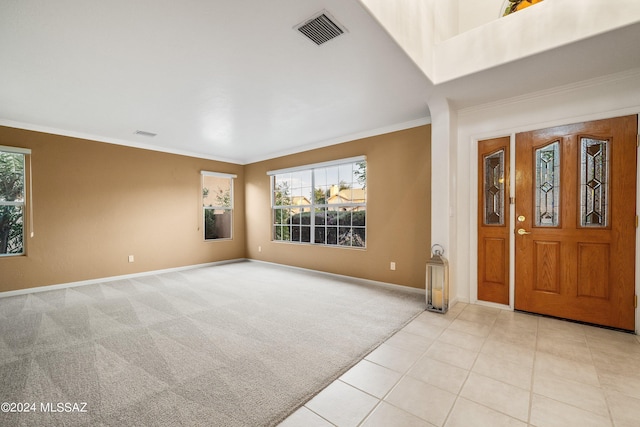 entryway with ornamental molding, a wealth of natural light, and light tile patterned floors