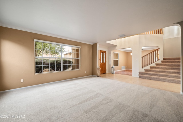 unfurnished living room with carpet and ornamental molding