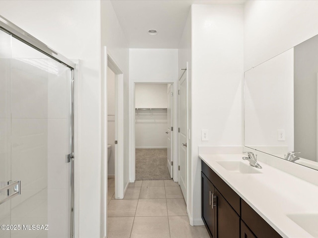 7005 W Jadewood Ln W, Tucson, AZ 85757 - bathroom with tile patterned floors, a walk in closet, a stall shower, a sink, and double vanity