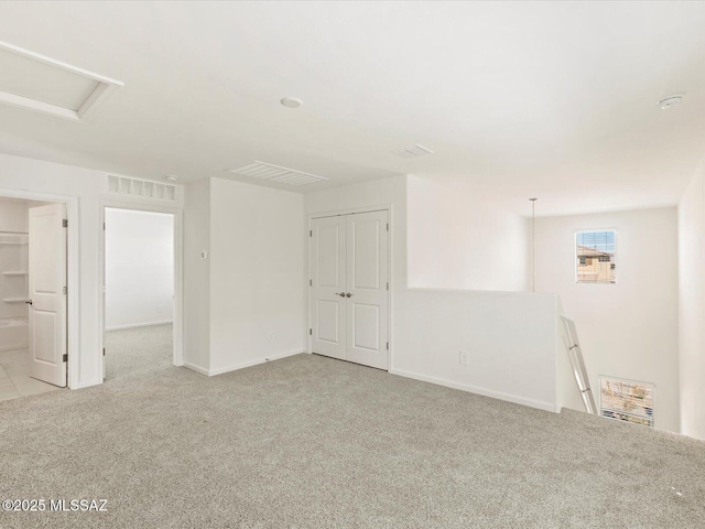 7005 W Jadewood Ln W, Tucson, AZ 85757 - empty room with baseboards, visible vents, light carpet, and attic access