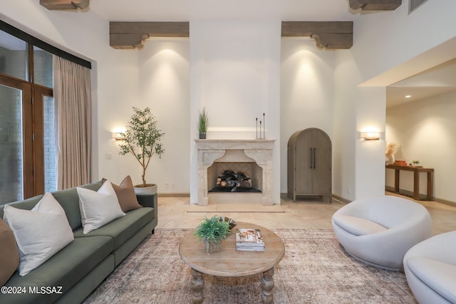 living room with a premium fireplace and a towering ceiling