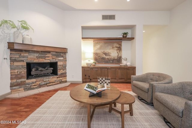 living room featuring light wood-type flooring and a stone fireplace