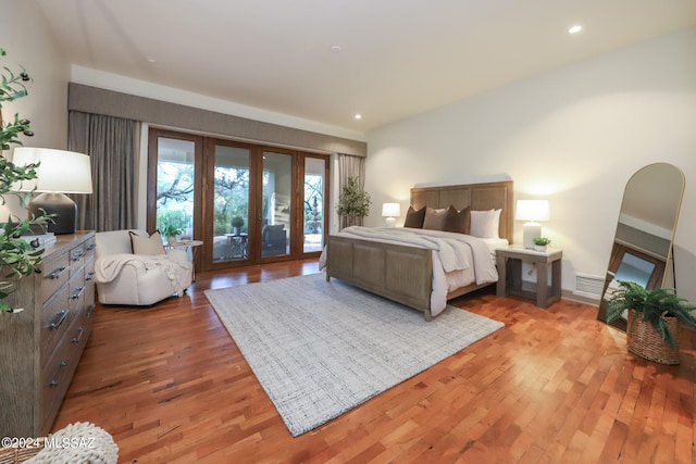 bedroom with hardwood / wood-style floors and access to exterior