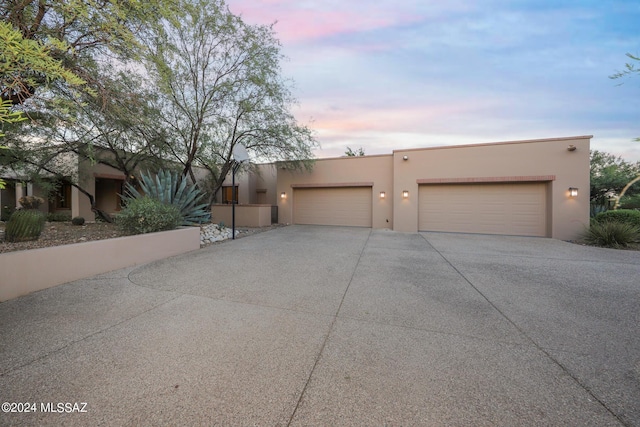 pueblo revival-style home with a garage