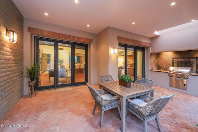 view of patio / terrace with an outdoor kitchen, french doors, and a grill