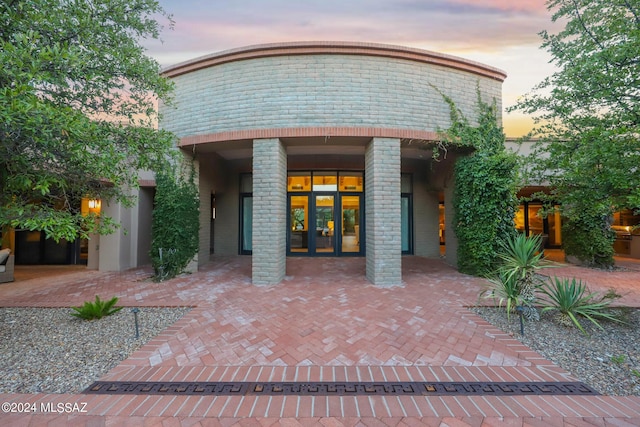 exterior entry at dusk featuring french doors