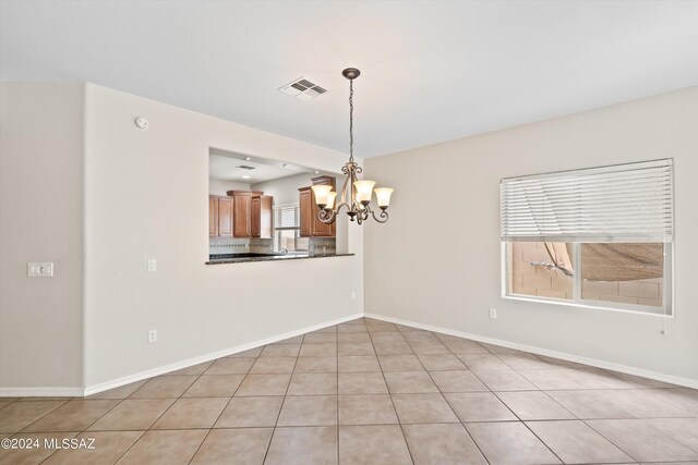 tiled empty room with a chandelier