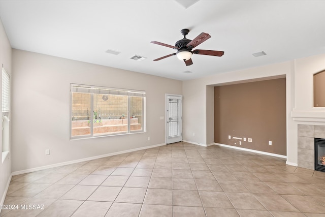 unfurnished living room featuring light tile patterned flooring, ceiling fan, and a tile fireplace