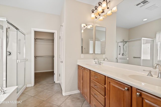 bathroom featuring tile patterned floors, a shower with shower door, and vanity