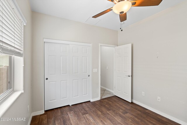 unfurnished bedroom with a closet, ceiling fan, and dark hardwood / wood-style floors