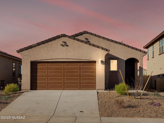 mediterranean / spanish house with stucco siding, driveway, and an attached garage