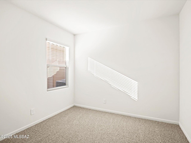 unfurnished room with baseboards and light colored carpet