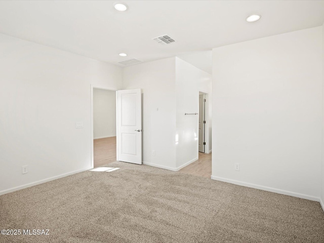 unfurnished room featuring recessed lighting, visible vents, light colored carpet, and baseboards