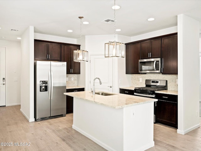 kitchen with visible vents, a sink, dark brown cabinets, appliances with stainless steel finishes, and a notable chandelier