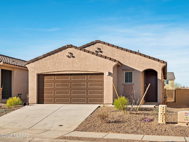 mediterranean / spanish home with driveway, an attached garage, and stucco siding