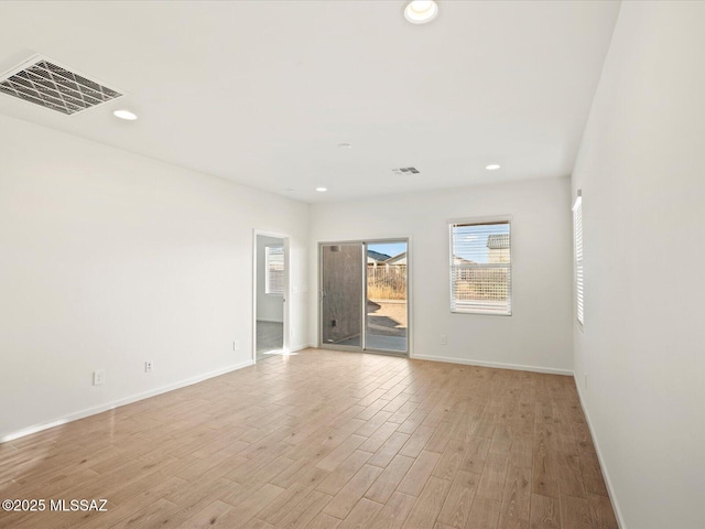 unfurnished room with visible vents, recessed lighting, light wood-type flooring, and baseboards