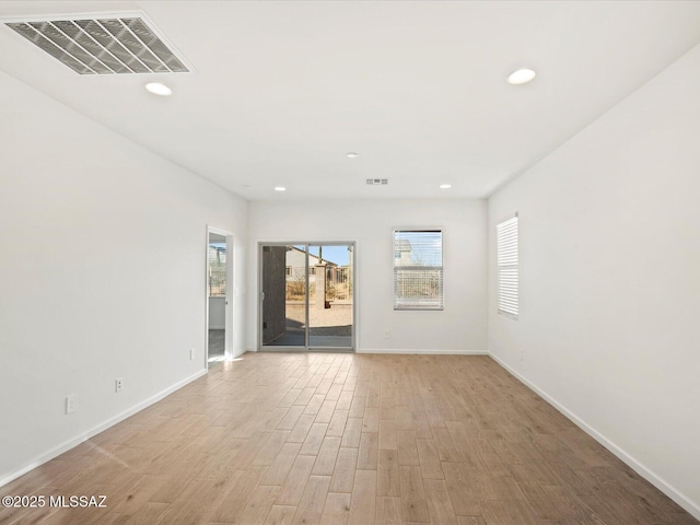 spare room featuring light wood-style flooring, recessed lighting, visible vents, and baseboards