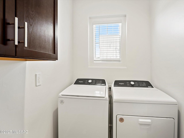 clothes washing area featuring cabinet space and washing machine and dryer