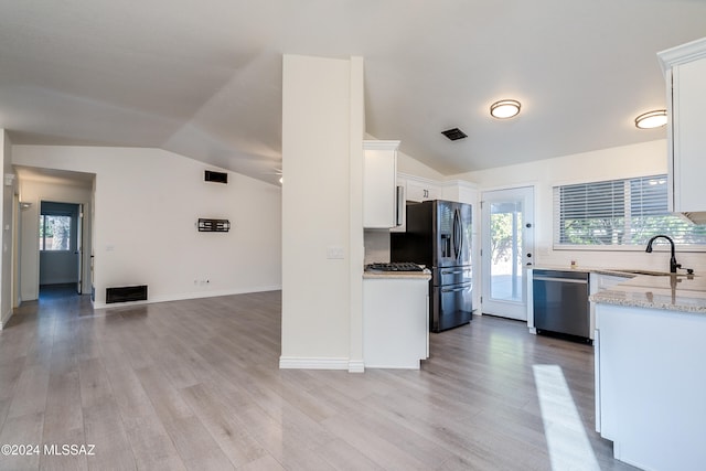 kitchen with vaulted ceiling, dishwasher, light hardwood / wood-style floors, sink, and white cabinets