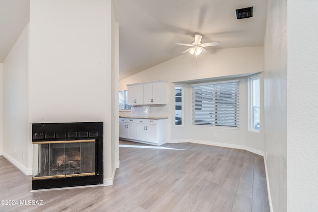 unfurnished living room with light wood-type flooring, ceiling fan, and vaulted ceiling