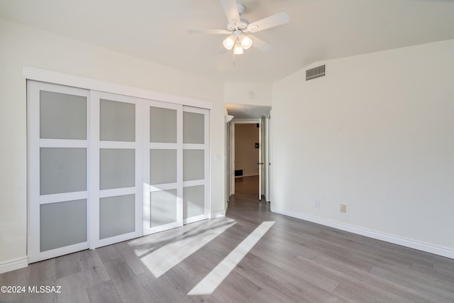 unfurnished room with light hardwood / wood-style floors, lofted ceiling, and ceiling fan