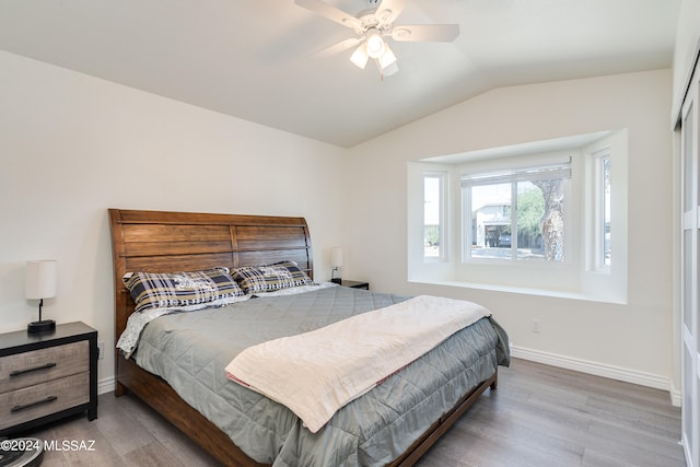 bedroom with ceiling fan, lofted ceiling, and hardwood / wood-style flooring