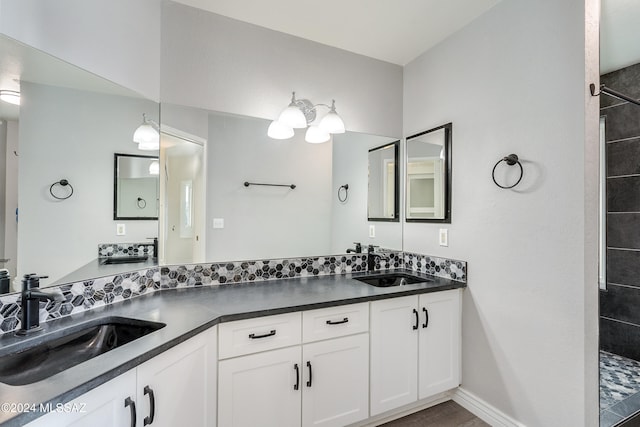 bathroom with tiled shower and vanity