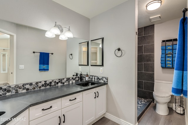 bathroom featuring hardwood / wood-style flooring, toilet, vanity, and walk in shower