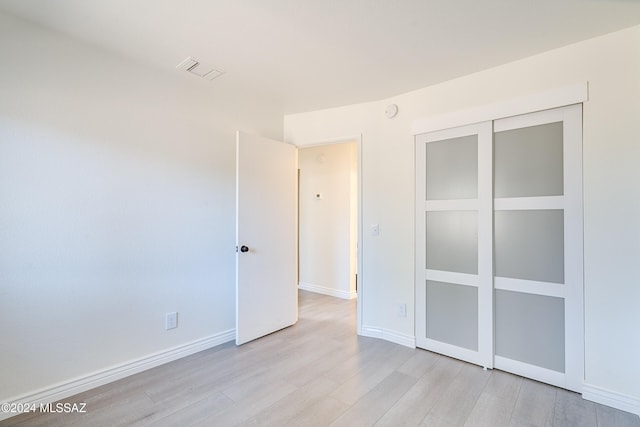 unfurnished bedroom featuring a closet and light hardwood / wood-style flooring