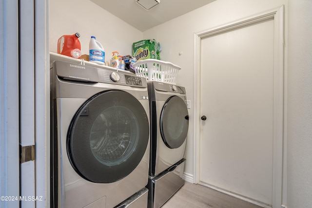 washroom with washing machine and dryer and light wood-type flooring