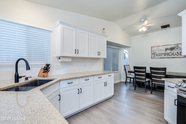 kitchen featuring tasteful backsplash, ceiling fan, light hardwood / wood-style floors, sink, and white cabinetry