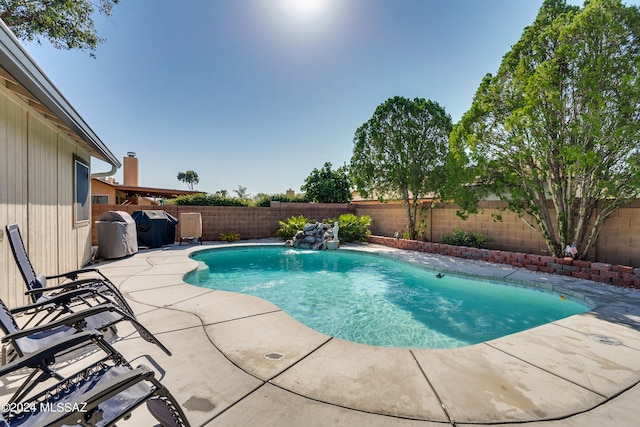 view of pool with pool water feature and a patio