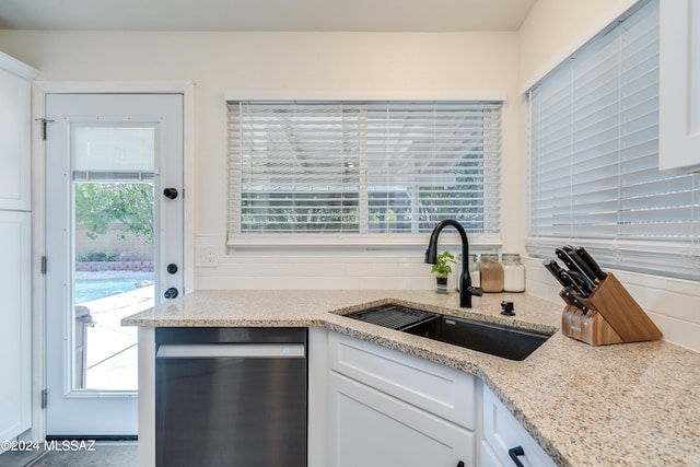 kitchen featuring light stone countertops, dishwasher, white cabinets, and sink