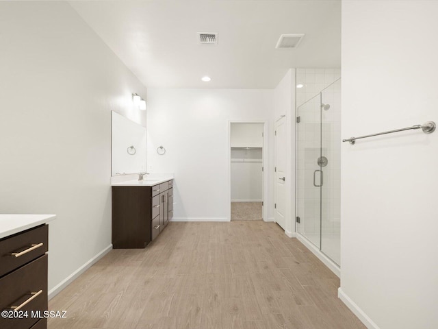 bathroom featuring vanity, hardwood / wood-style floors, and a shower with shower door