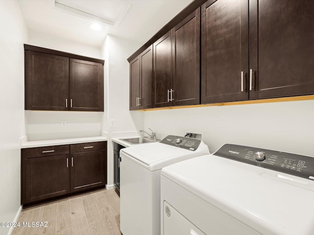 washroom featuring sink, cabinets, and washing machine and clothes dryer