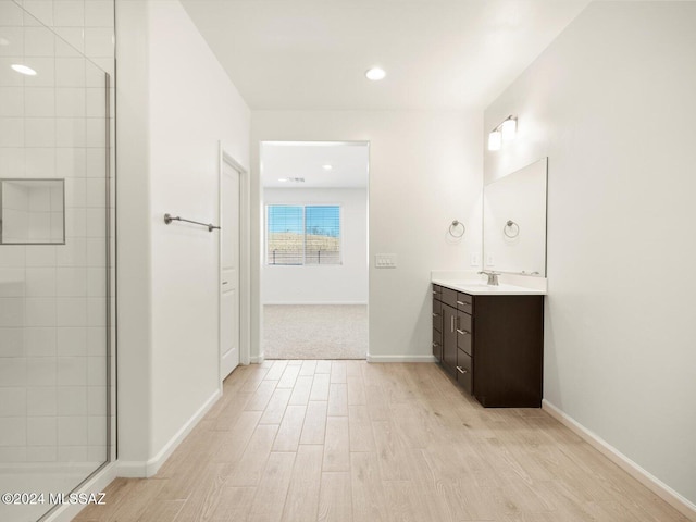 bathroom with a shower with door, vanity, and hardwood / wood-style floors