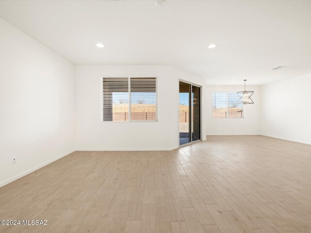 spare room featuring a healthy amount of sunlight and light hardwood / wood-style floors