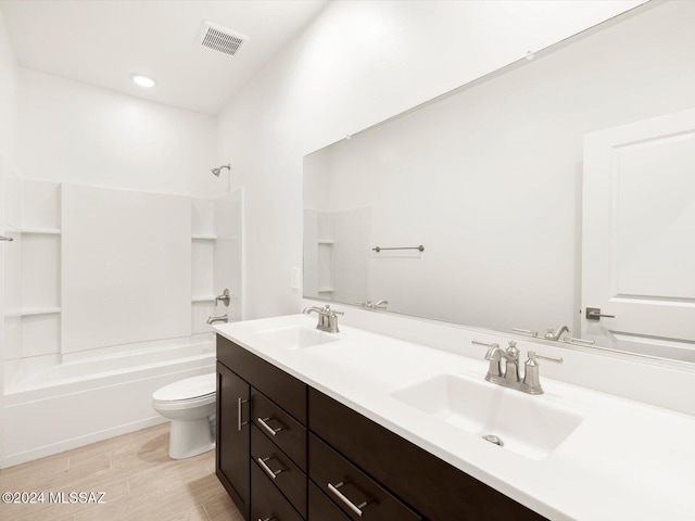 full bathroom featuring hardwood / wood-style flooring, bathing tub / shower combination, vanity, and toilet