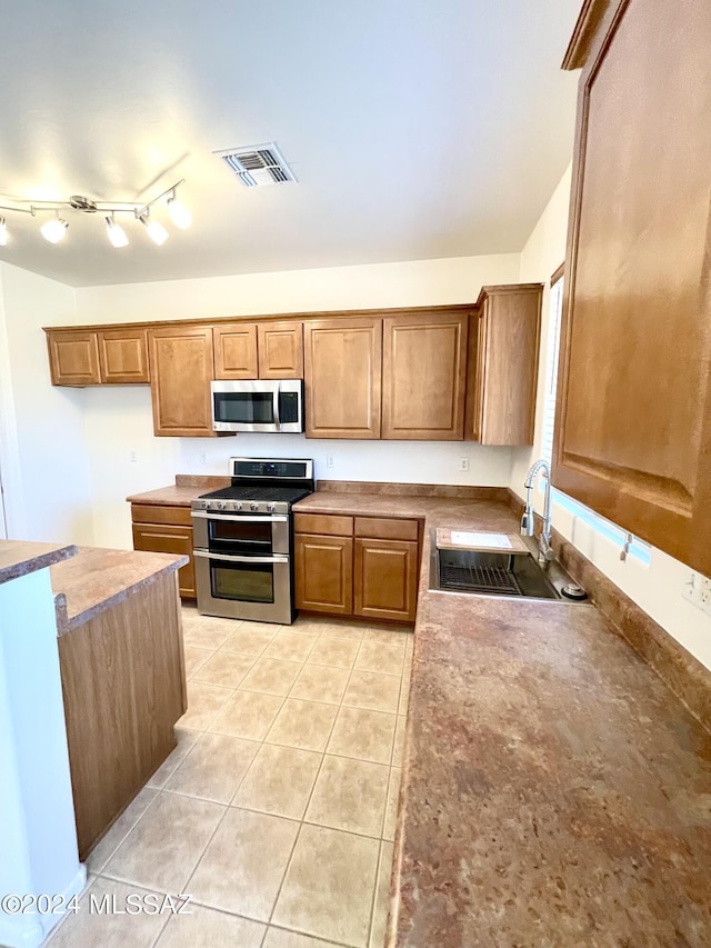 kitchen featuring sink, stainless steel appliances, and light tile patterned flooring