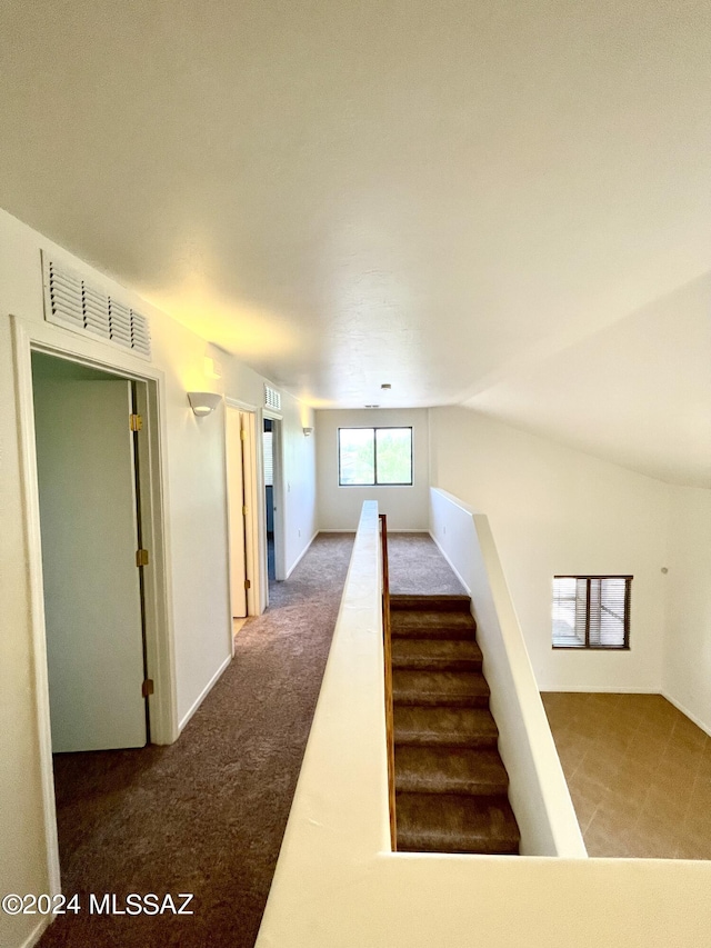 staircase featuring carpet and lofted ceiling