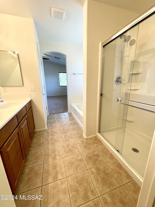 bathroom featuring plus walk in shower, tile patterned flooring, and vanity