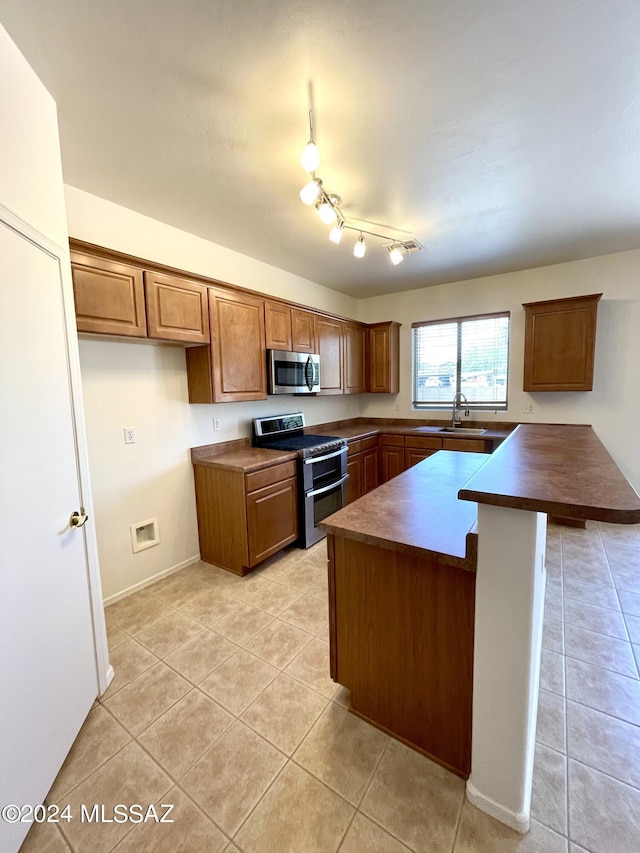 kitchen with light tile patterned floors, stainless steel appliances, and sink