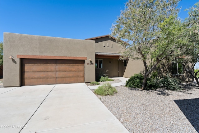 pueblo-style home featuring a garage