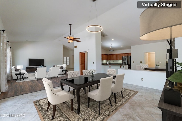 tiled dining area featuring ceiling fan and lofted ceiling