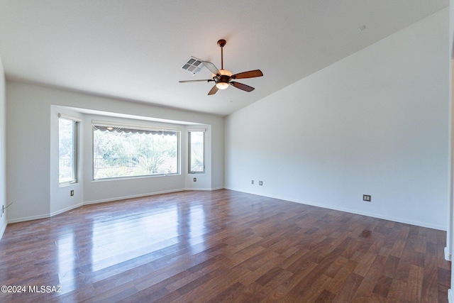 empty room with ceiling fan, vaulted ceiling, and dark hardwood / wood-style flooring