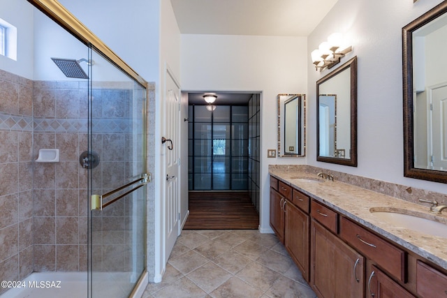 bathroom featuring tile patterned flooring, an enclosed shower, and vanity