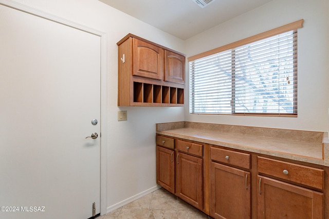 clothes washing area featuring light tile patterned flooring