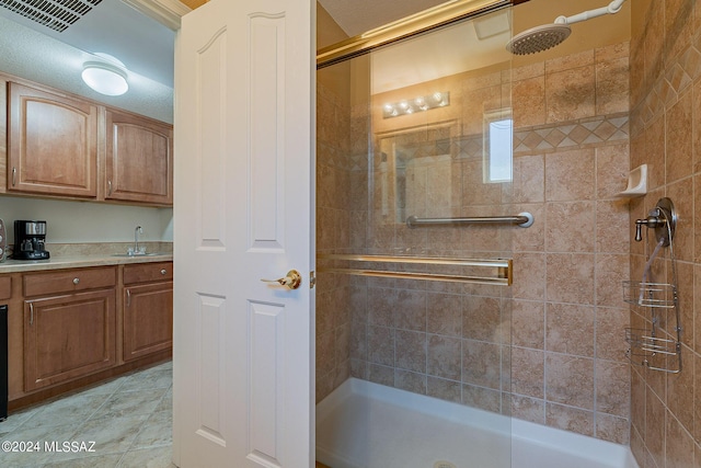 bathroom with tiled shower and vanity