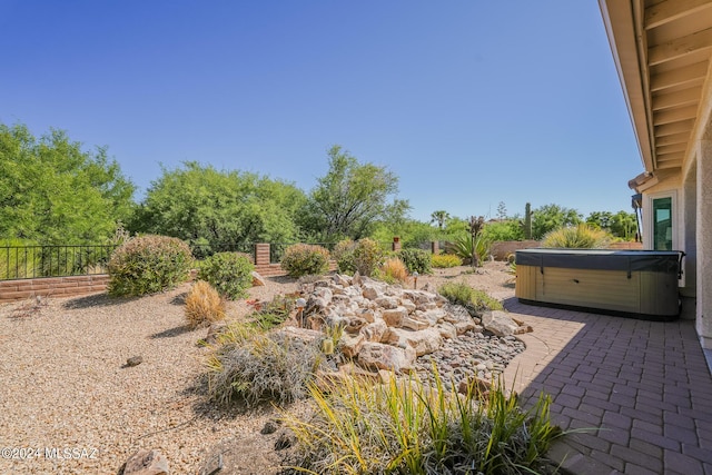 view of yard featuring a patio area and a hot tub